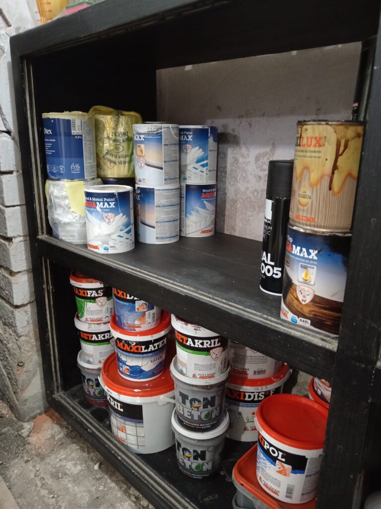 Polica sa organizovanim bojama za drvo i bojama za zidove