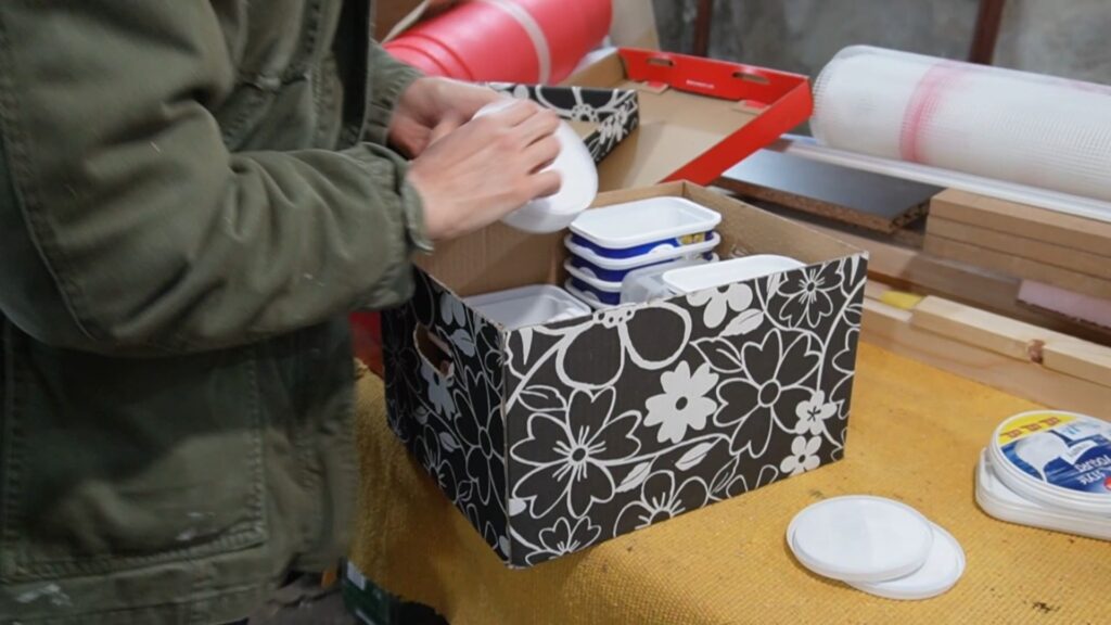 Reciklirane plastične kutije složene u veću kutiju za kasniju upotrebu u radionici.