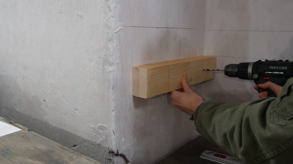 Prislonjen nosač police na zid tokom obeležavanja mesta za bušenje.