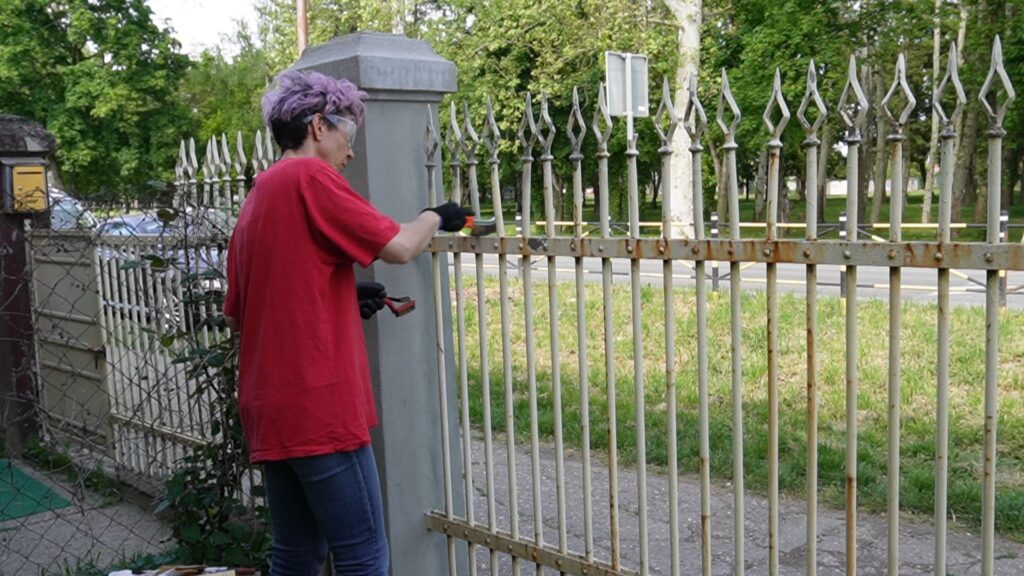 Ručno čišćenje metalne ograde žičanom četkom