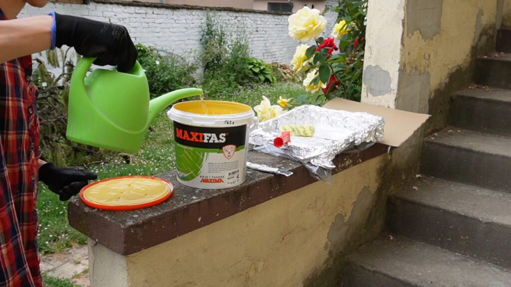 Priprema fasadne boje za farbanje stubova ograde.