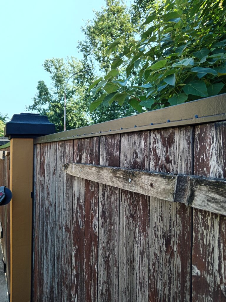 Čelični firiket na metalnom okviru ograde koji drži stare drvene panele