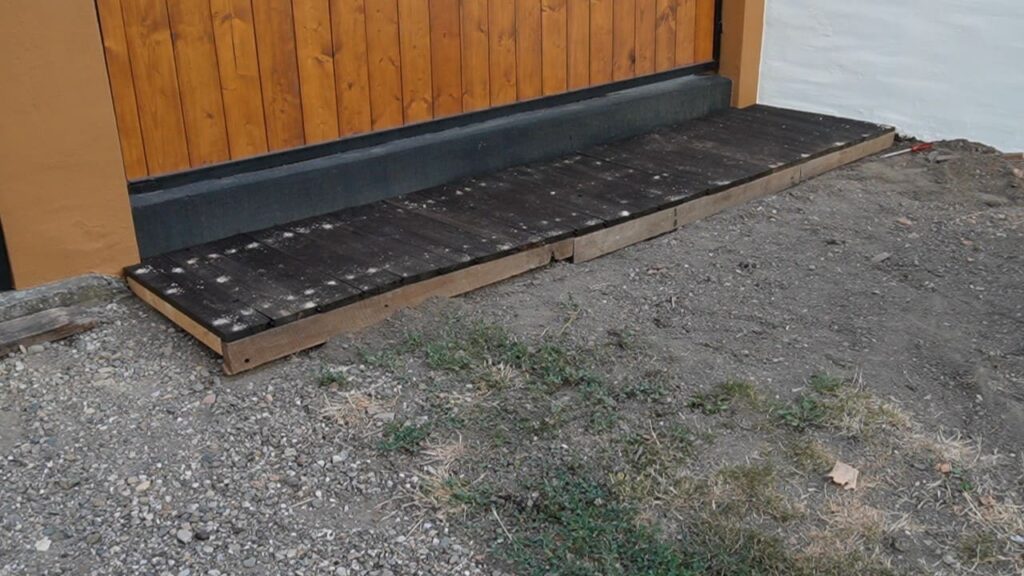 Drvena platforma uz ogradu sa dodatim daskama duž prednje i bočne ivice