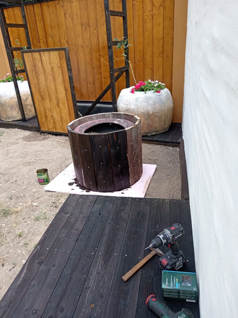Žardinjera obložena uspravnim daskama brodskog poda, sa vidljivom gumom u unutrašnjosti